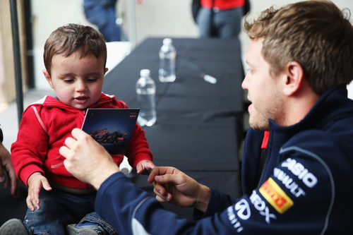 Sebastian Vettel le firma un autógrafo a un niño