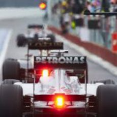 Lewis Hamilton pasa por una concurrida calle de boxes