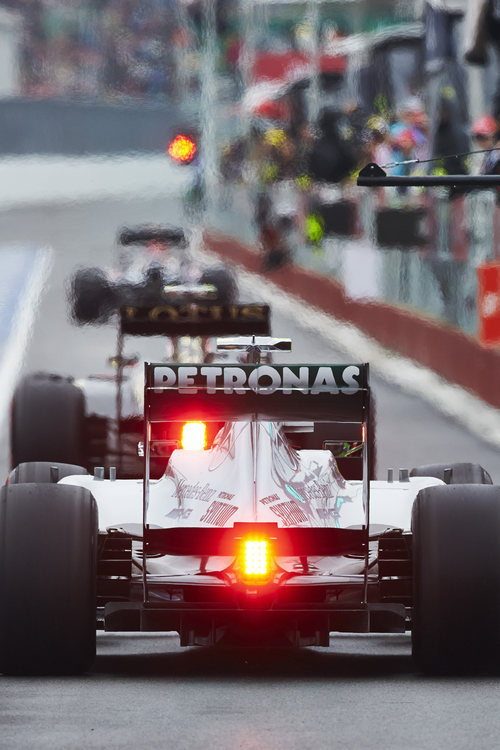 Lewis Hamilton pasa por una concurrida calle de boxes