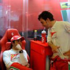 Fernando Alonso y Felipe Massa charlan en el box de Ferrari