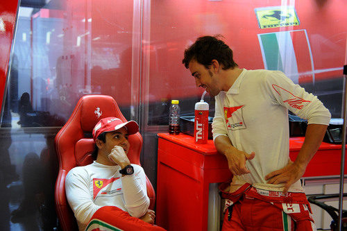 Fernando Alonso y Felipe Massa charlan en el box de Ferrari