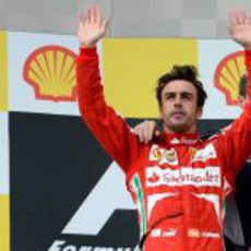 Fernando Alonso saluda al público desde el podio