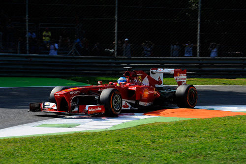 Fernando Alonso pasa junto a uno de los pianos en Monza
