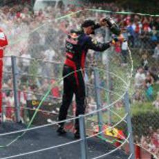 Mark Webber y Fernando Alonso echan champán a los aficionados