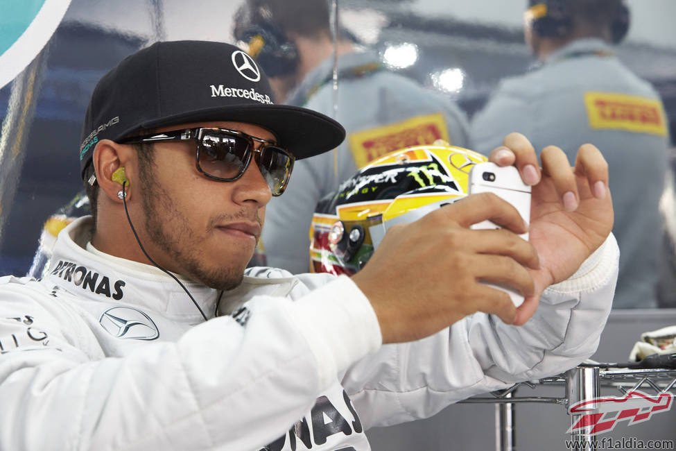 Lewis Hamilton jugando con su móvil