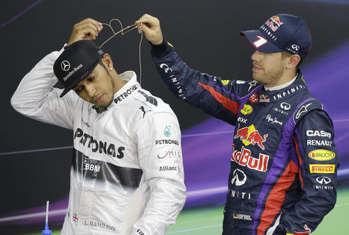 Sebastian Vettel ayuda a Lewis Hamilton con el micrófono