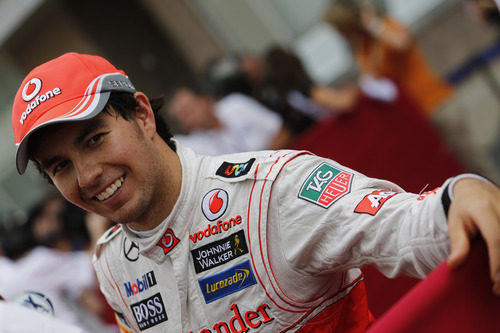 Sergio Pérez se muestra sonriente en el paddock