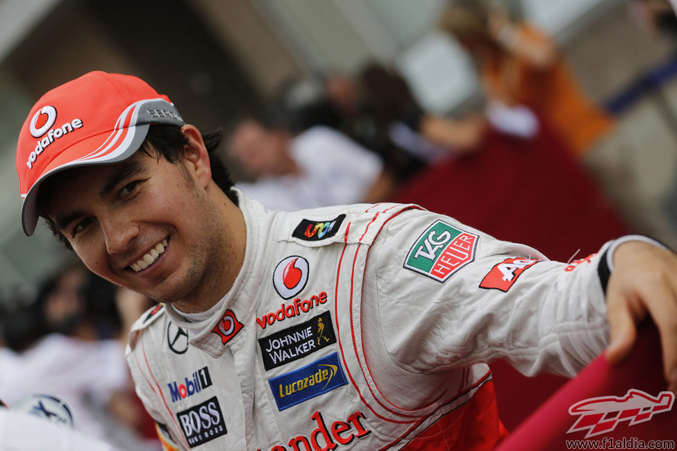 Sergio Pérez se muestra sonriente en el paddock