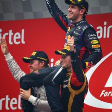 Nico Rosberg y Romain Grosjean aúpan a Sebastian Vettel