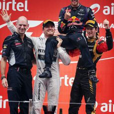 Rosberg y Grosjean levantan a Vettel en el podio
