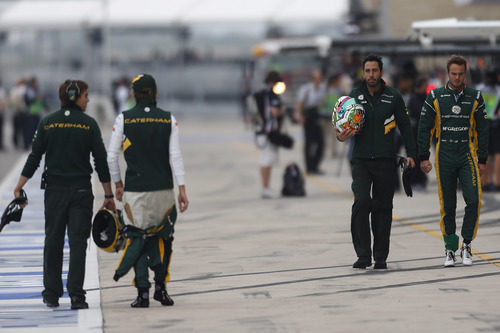 Los pilotos de Caterham regresan por el pit lane