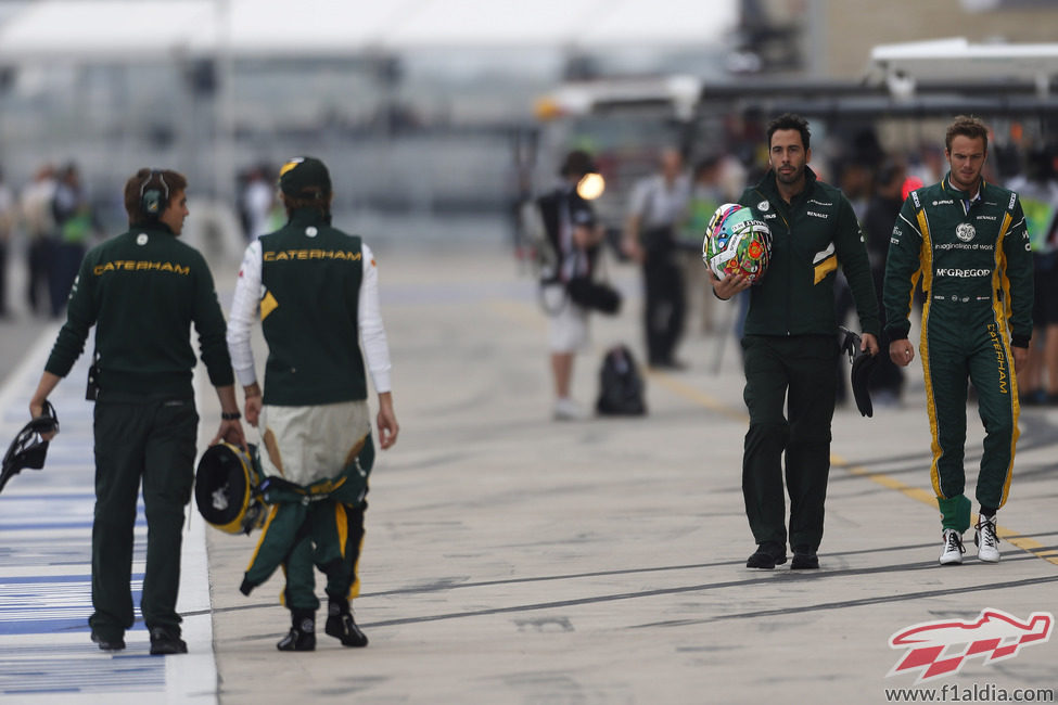 Los pilotos de Caterham regresan por el pit lane