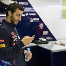 Daniel Ricciardo se entretiene con el móvil en el box de Toro Rosso en Brasil