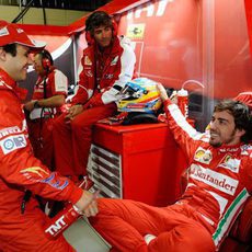 Fernando Alonso y Felipe Massa charlan en el box