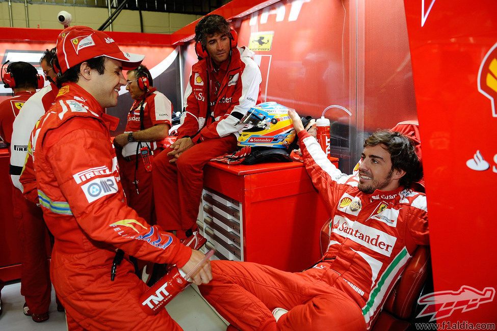 Fernando Alonso y Felipe Massa charlan en el box