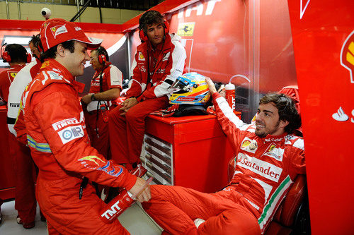 Fernando Alonso y Felipe Massa charlan en el box