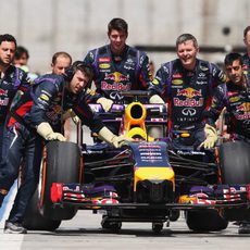 Los mecánicos de Red Bull empujan el coche hasta el garaje