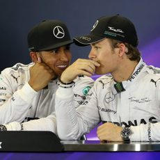 Lewis Hamilton y Nico Rosberg cuchichean en rueda de prensa