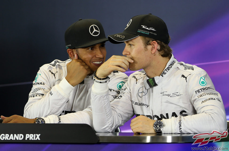 Lewis Hamilton y Nico Rosberg cuchichean en rueda de prensa
