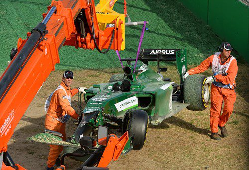 La grúa retira de la gravilla el monoplaza de Kamui Kobayashi