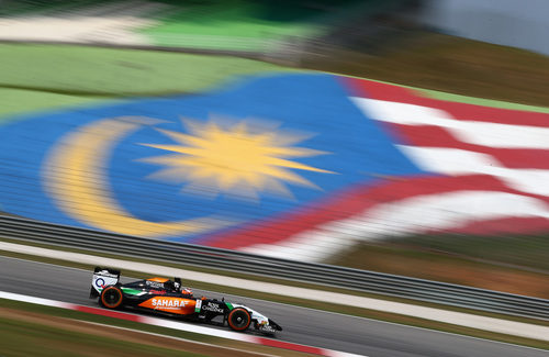 Nico Hülkenberg pasa por delante de una gran bandera de Malasia