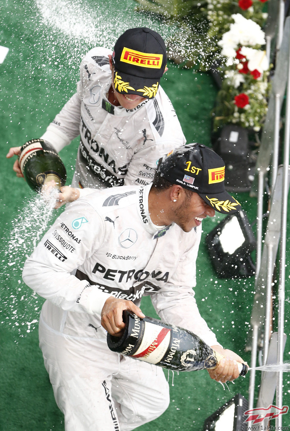 Lewis Hamilton y Nico Rosberg celebran con champán el doblete en Sepang