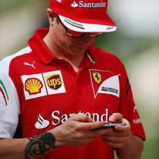 Kimi Räikkönen se entretiene con su móvil