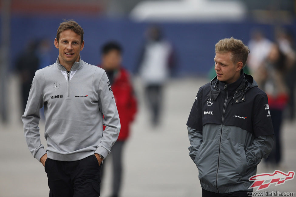 Kevin Magnussen y Jenson Button por el paddock