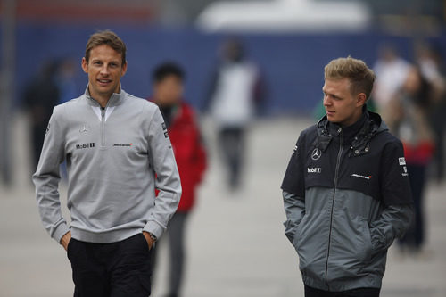 Kevin Magnussen y Jenson Button por el paddock