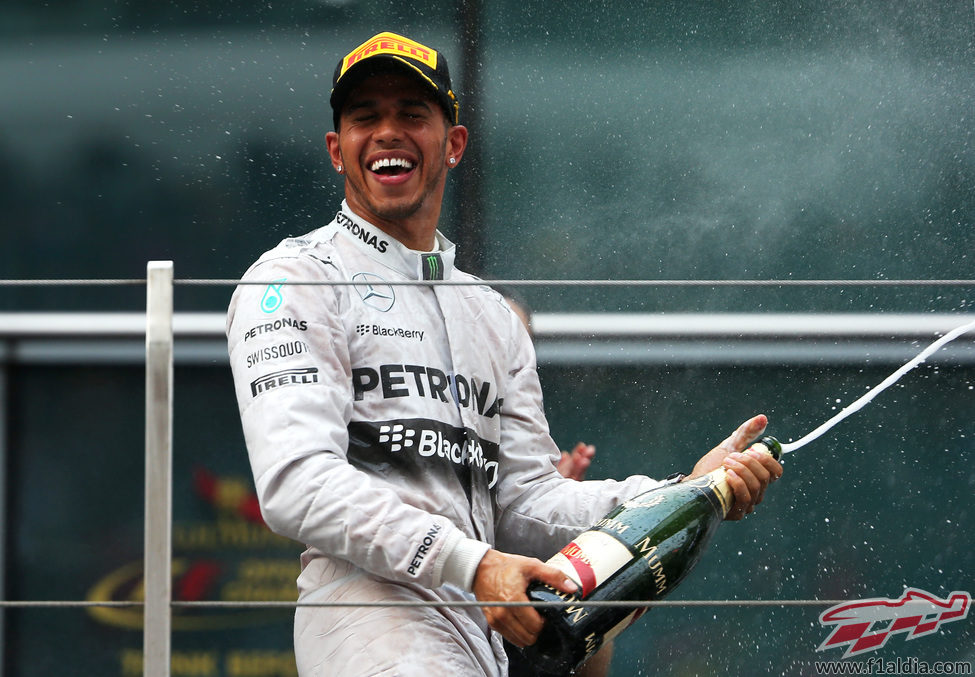 Lewis Hamilton descorcha la botella en el podio