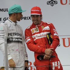 Fernando Alonso y Lewis Hamilton charlan en el podio