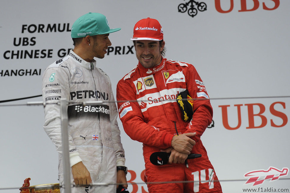 Fernando Alonso y Lewis Hamilton charlan en el podio