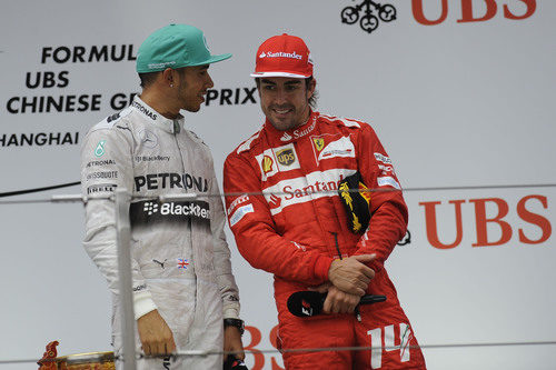 Fernando Alonso y Lewis Hamilton charlan en el podio