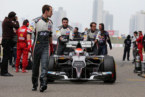 Adrian Sutil llevado por sus mecánicos hasta su posición de salida