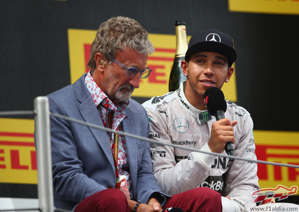 Eddie Jordan charla con Lewis Hamilton en el podio