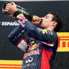 Daniel Ricciardo bebe champán en el podio