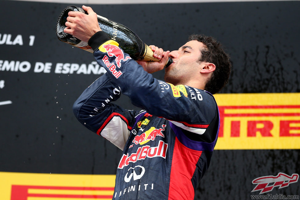 Daniel Ricciardo bebe champán en el podio