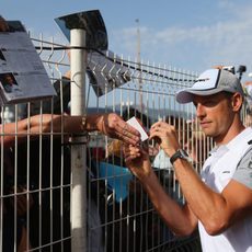 Jenson Button firma autógrafos a los fans