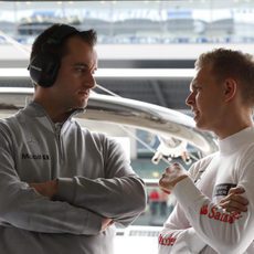 Kevin Magnussen hablando con un ingeniero en el garaje