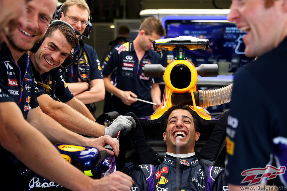 Daniel Ricciardo riendo feliz con sus mecánicos