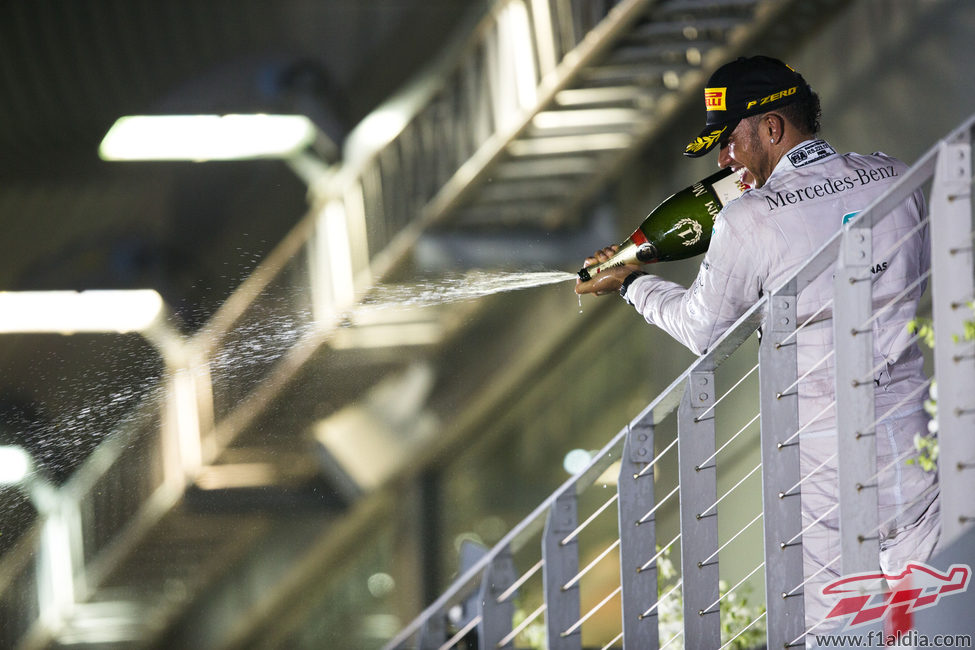 Lewis Hamilton lanza champán desde el podio