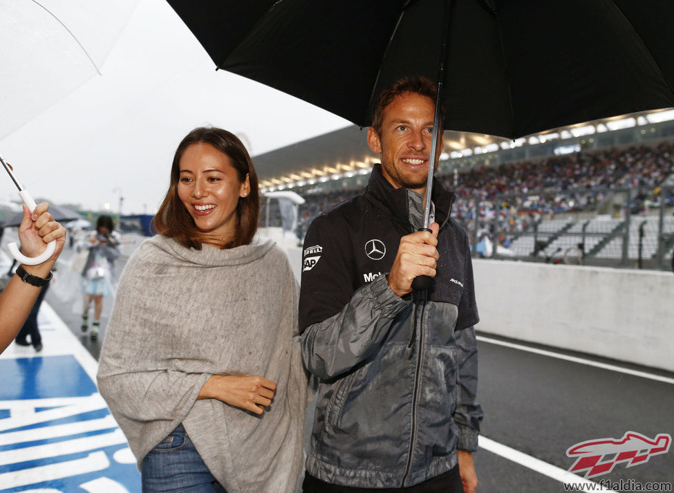 Jenson Button y Jessica Michibata pasean bajo la lluvia