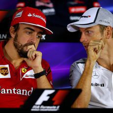 Fernando Alonso y Jenson Button comentan algo en rueda de prensa