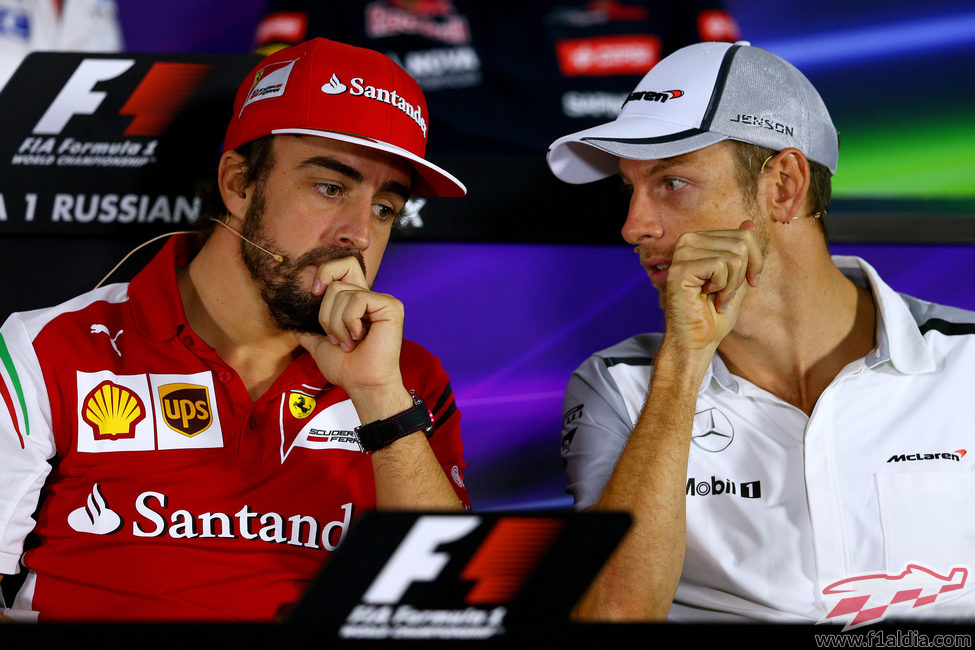 Fernando Alonso y Jenson Button comentan algo en rueda de prensa