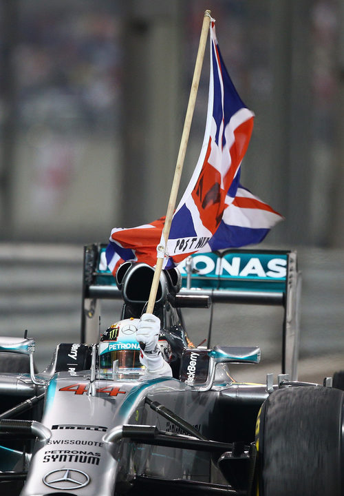 Lewis Hamilton sostiene la bandera de Reino Unido