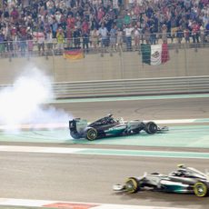 Lewis Hamilton haciendo 'donuts' mientras Nico Rosberg pasa a su lado