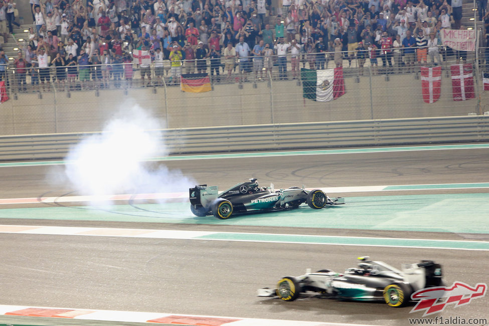 Lewis Hamilton haciendo 'donuts' mientras Nico Rosberg pasa a su lado