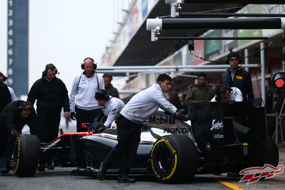 Los mecánicos llevan a Jenson Button de vuelta al box