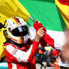 Sebastian Vettel coge la bandera de Ferrari para celebrar el triunfo