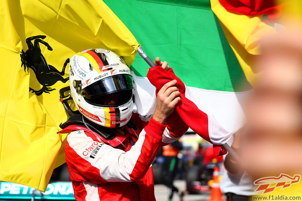 Sebastian Vettel coge la bandera de Ferrari para celebrar el triunfo